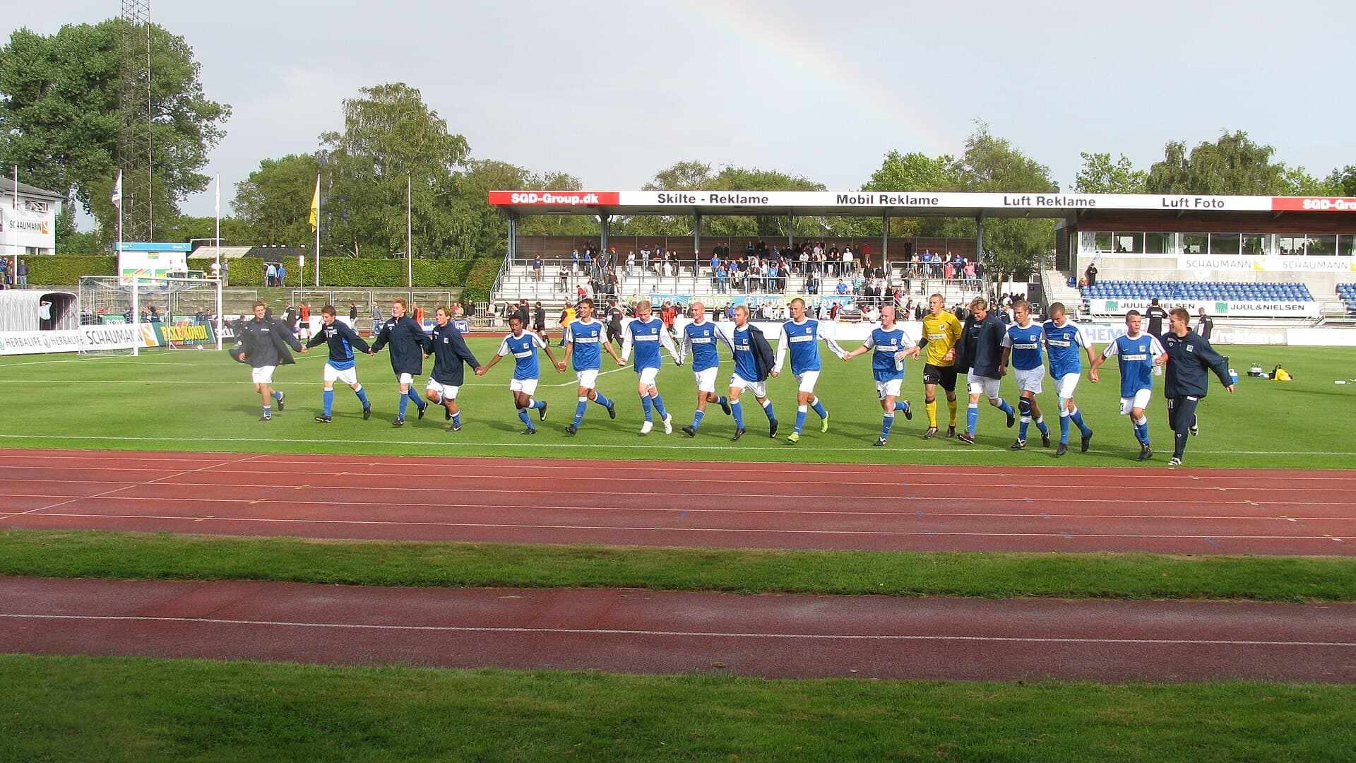Lyngby-spillere i blå trøjer hilser på publikum efter en kamp på Lyngby Stadion